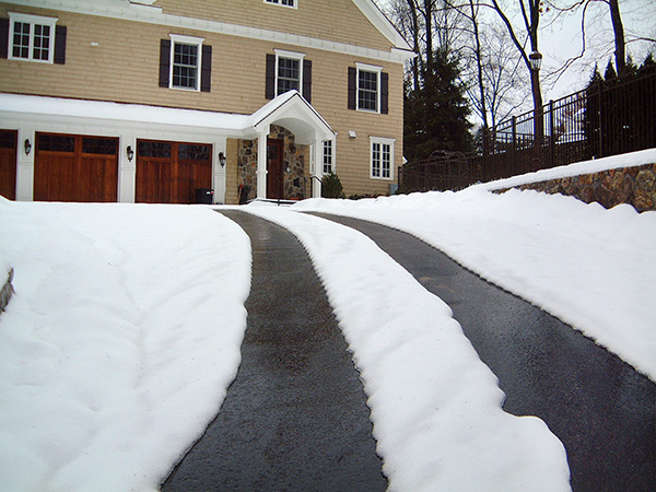 Heated tire tracks in asphalt driveway.