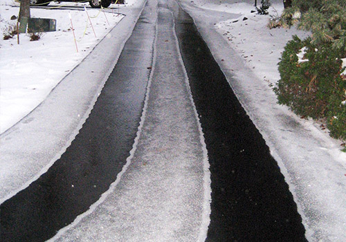 Radiant heat installed to heat tire tracks in long asphalt driveway.